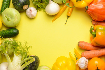 Frame made of fresh vegetables on color background