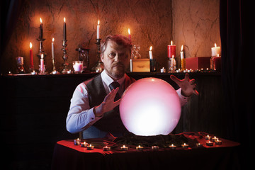 man fortune teller with illuminated crystal ball