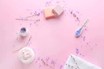 Frame made of natural cosmetics with towel and lavender on color background