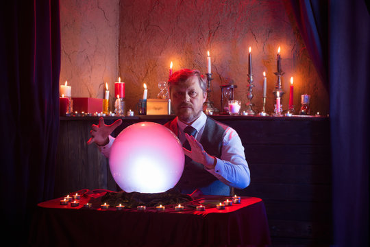 man fortune teller with illuminated crystal ball