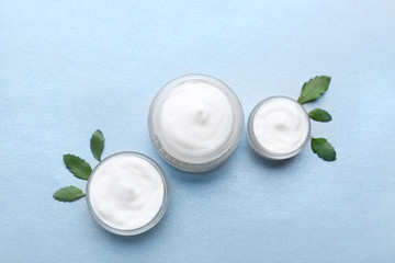 Jars of natural cream on light background