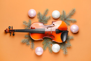 Violin and Christmas decor on color background