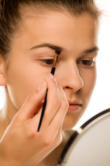 closeup of woman shaping her eyebrows with brush