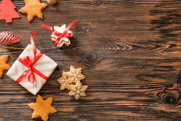Composition with tasty Christmas cookies and gift on wooden table