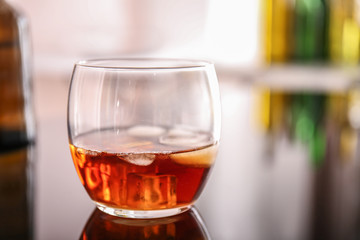Glass of whiskey on table in bar