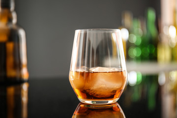 Glass of whiskey on table in bar