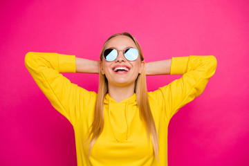 Photo of nice lady holding hands behind head relaxing wear sun specs yellow hoodie pullover isolated pink background