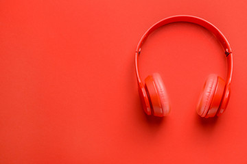 Modern headphones on color background