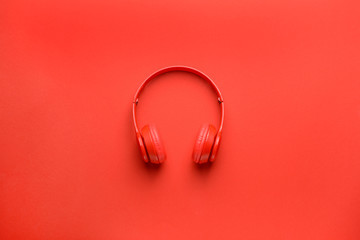 Modern headphones on color background