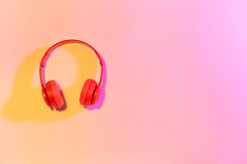 Modern headphones on color background