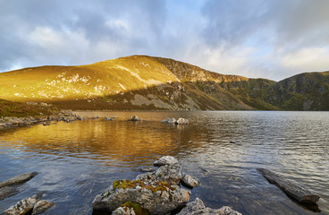 The early morning Autumn light falling across the Mountain overlooking Loch Brandy at Glen Clova,...