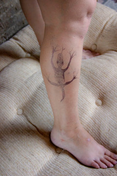 lizard is painted on the legs. Varicose veins on female legs.