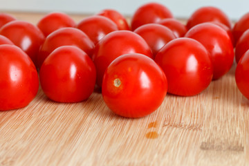 the harvest of ripe tomatoes is on the wooden kitchen table