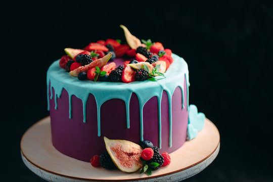 Fruit cake decorated with figs, blueberries, raspberries and mint.