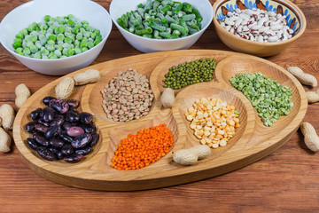 Various uncooked dried and frozen legumes on the rustic table