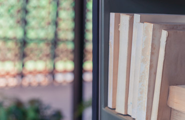 Naklejka na ściany i meble Old textbook and books on shelf in library with beatiful blurred bokeh background