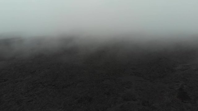 aerial of mauna loa lava fields through fog