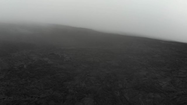 Mauna Loa aerial of lava fields at 10000 feet layered in fog.
