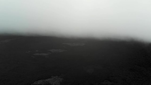 Aerial of Mauna Loa lava fields at 10000 foot elevation through fog.