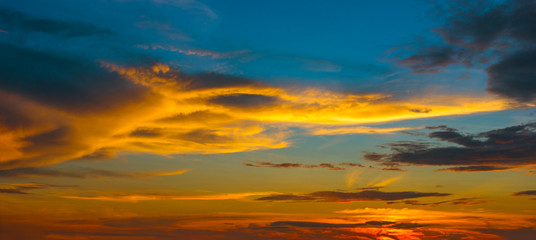 Naklejka na ściany i meble Beautiful Sunset in the sky with sky blue and orange light of the sun through the clouds in the sky, Orange and red dramatic colors - Image