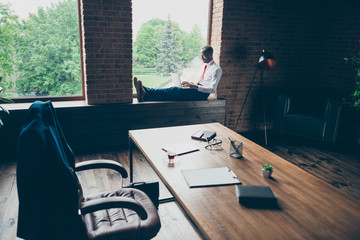 Dark skin guy sitting on window talking skype with relatives wear elegant costume without jacket