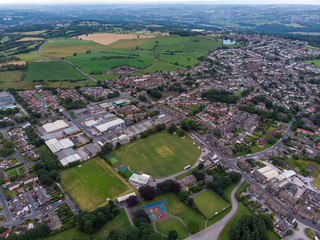 Aerial photo of the town known as Yeadon within the metropolitan borough of the City of Leeds, West Yorkshire, England, showing typical British houses, roads and streets with fields close by.