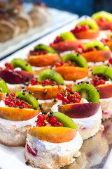 Sweet small cakes with cream and fruit