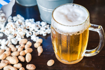 Beer glass with nuts and popcorn
