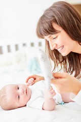 Mother carefully changes the baby diapers