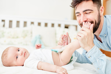 Happy father changes baby diapers