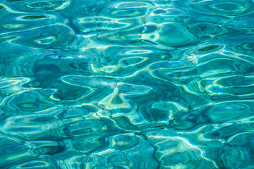 Turquoise sea surface with transparent shallow water - pebbles, stones, rocks on the seabed