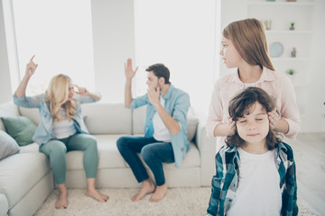 Young family two children avoid listening parents quarrel hiding ears tired hear yelling