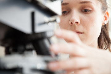 Laboratory assistant uses a polarizing microscope in a microbiological laboratory