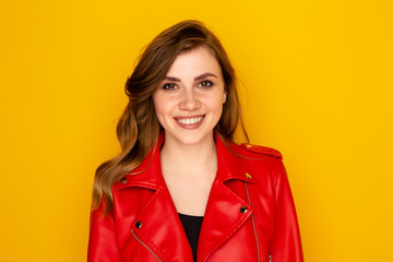 Portrait of pretty young woman in the red clothes isolated over the yellow background