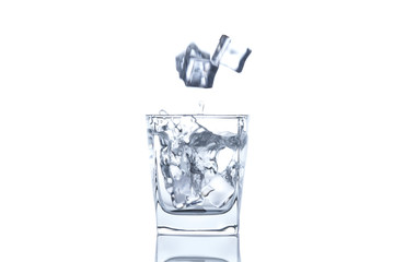 The ice cube splash into glass of water