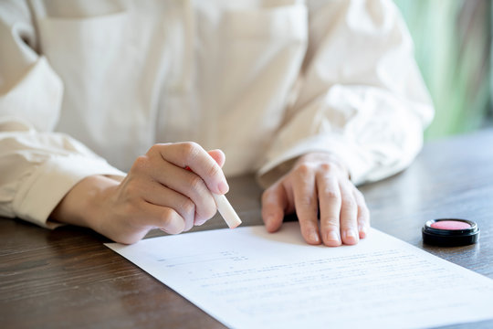 書類に捺印する女性の手元