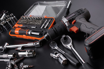 Industrial locksmith tools and screwdriver on a black background
