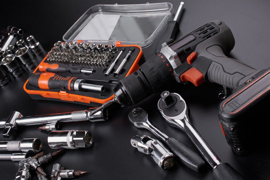 Industrial locksmith tools and screwdriver on a black background