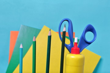 Color pencils in green shades. Scissors, glue and colored paper for application. They are located...