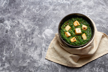 Palak Paneer with chapati and basmati rice at grey concrete background. Palak paneer or green paneer - is the indian cuisine vegetarian dish mades of spinach and paneer cheese. Copy space