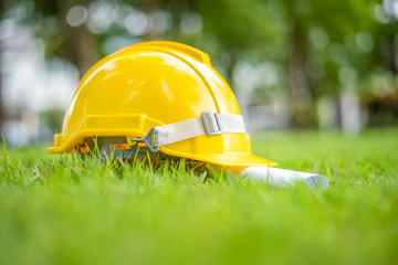 Yellow helmet on green background, save earth engineering concept