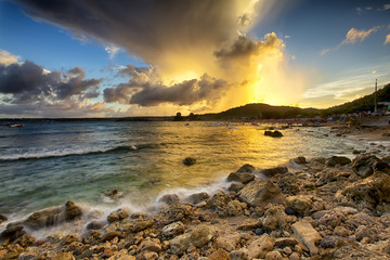 White waves crashing on the rocks at sunset