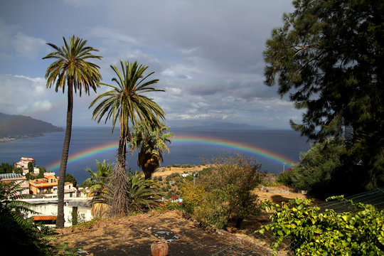 amazing rainbow on the sky in taormina sicilt tourists taking photos