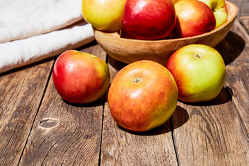 Fresh red apples with green leaves on a wooden old table. On a wooden background. Free space for text. soft focus