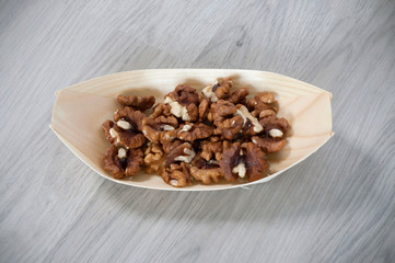 Greek walnut in a eco, wooden container isolated on wooden background
