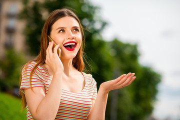 Portrait of charming lady with foxy ginger haircut using modern technology speaking outdoors