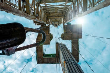 Oil and Gas Drilling Rig onshore dessert with dramatic cloudscape. Oil drilling rig operation on...