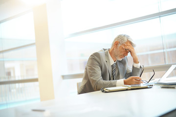 Exhausted businessman sitting at desk