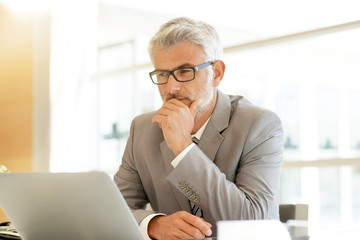 Businessman sitting at desk looking at computer