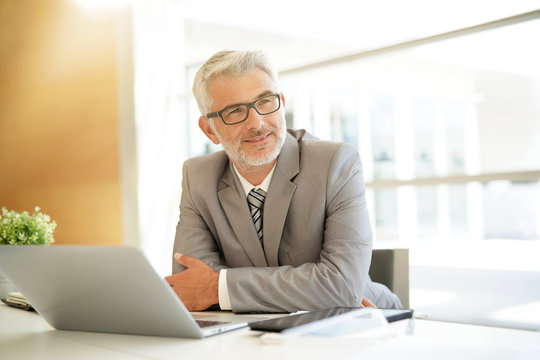 Content businessman sitting at desk
